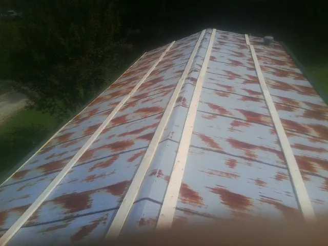 Rusted metal roof panels with new wood purlins before replacement — Storm Damage Roof Repair in Marseilles by Roofing Brothers