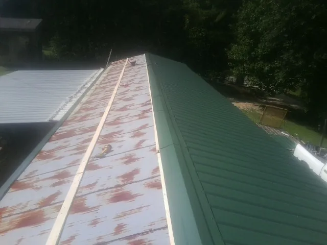 Old rusted panels beside newly installed green metal roofing — Wind Damage Roof Repair by Roofing Brothers in Marseilles