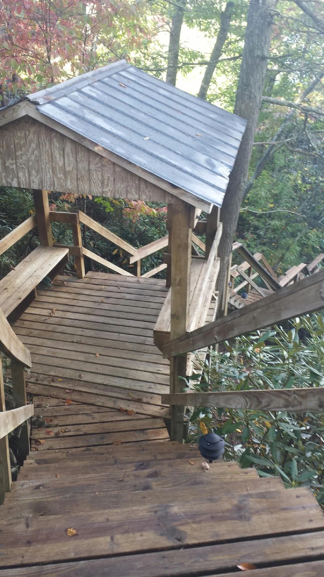 Metal roofed shelter over wooden steps on a wooded walkway — Skylight Repair & Installation work by our crew in Marseilles