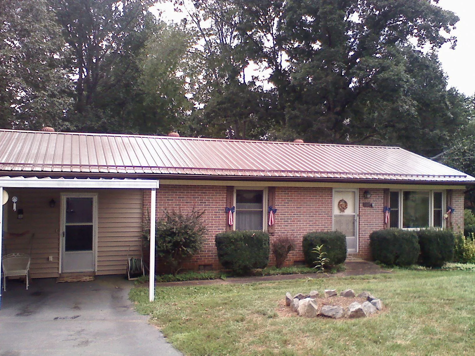 Bronze metal roof and carport on a brick ranch home — Roof Repair work by our crew in Marseilles